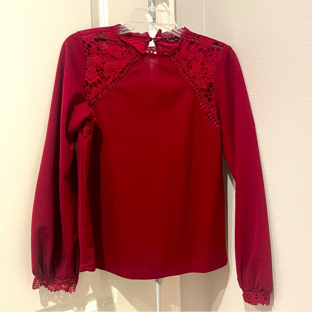 Wine colored top with lace details at the collar and sleeves